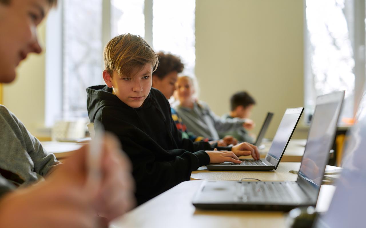 kind in de klas met laptop